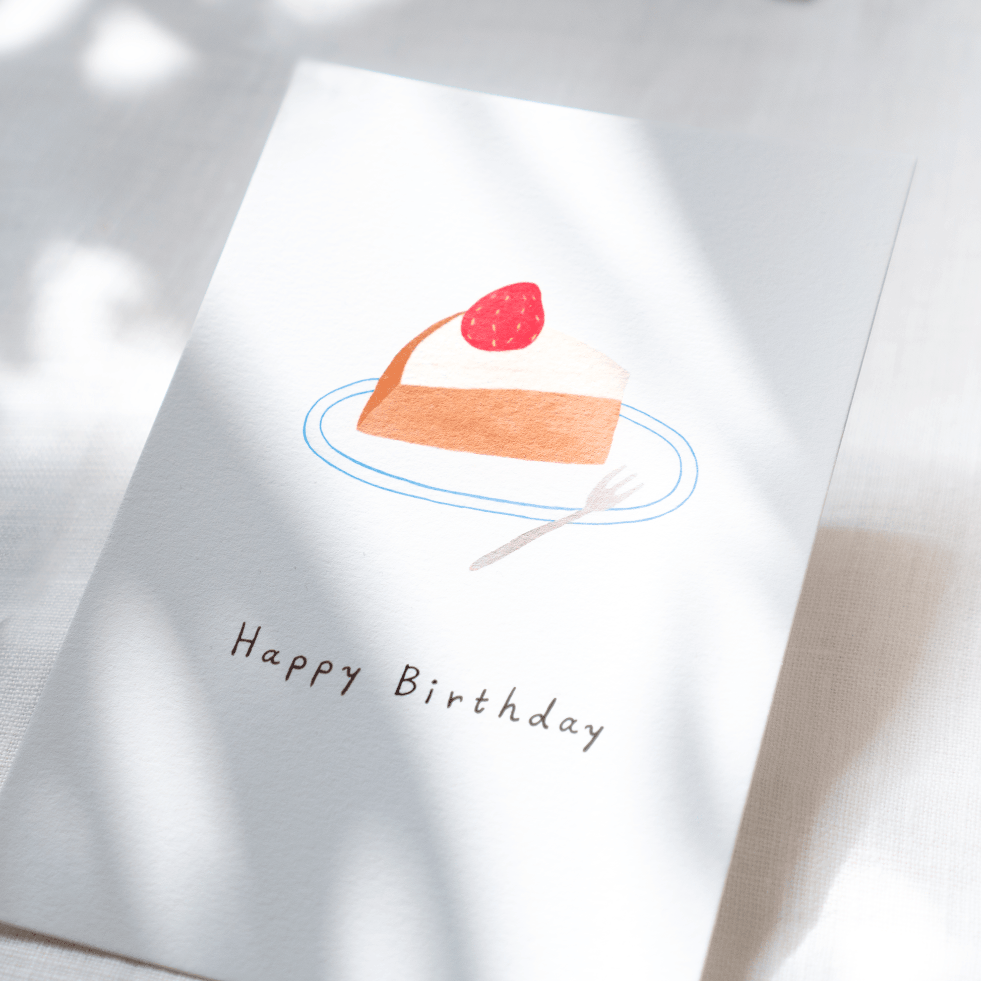 Greeting card with a cake illustration and 'Happy Birthday' text on a white background