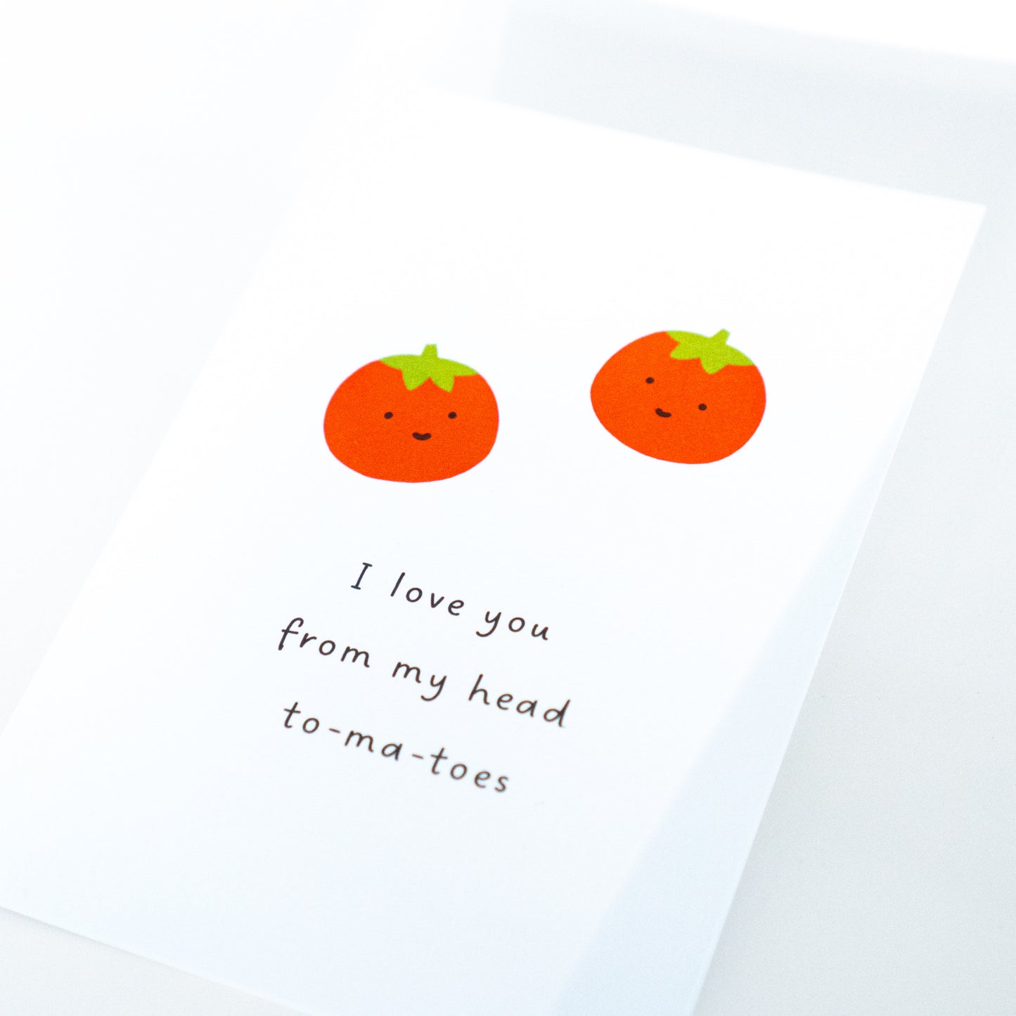 Card with cartoon tomatoes and text 'I love you from my head to-ma-toes' on a light blue background