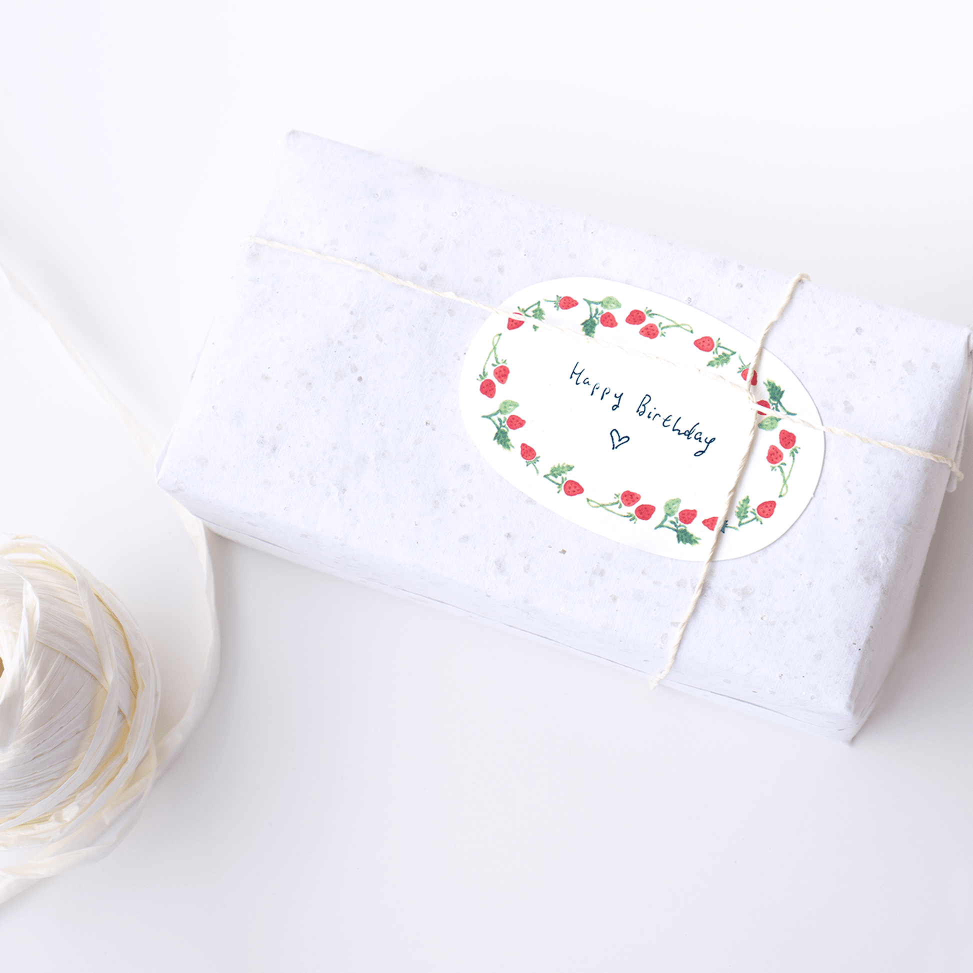 Mini card strawberry oval shape notecard gift card placed on wrapped gift with string