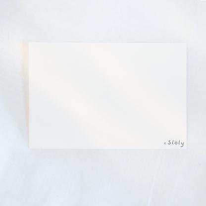 A blank white rectangular card with the small logo “*Söly” in the bottom-right corner, photographed on a soft white textured background.